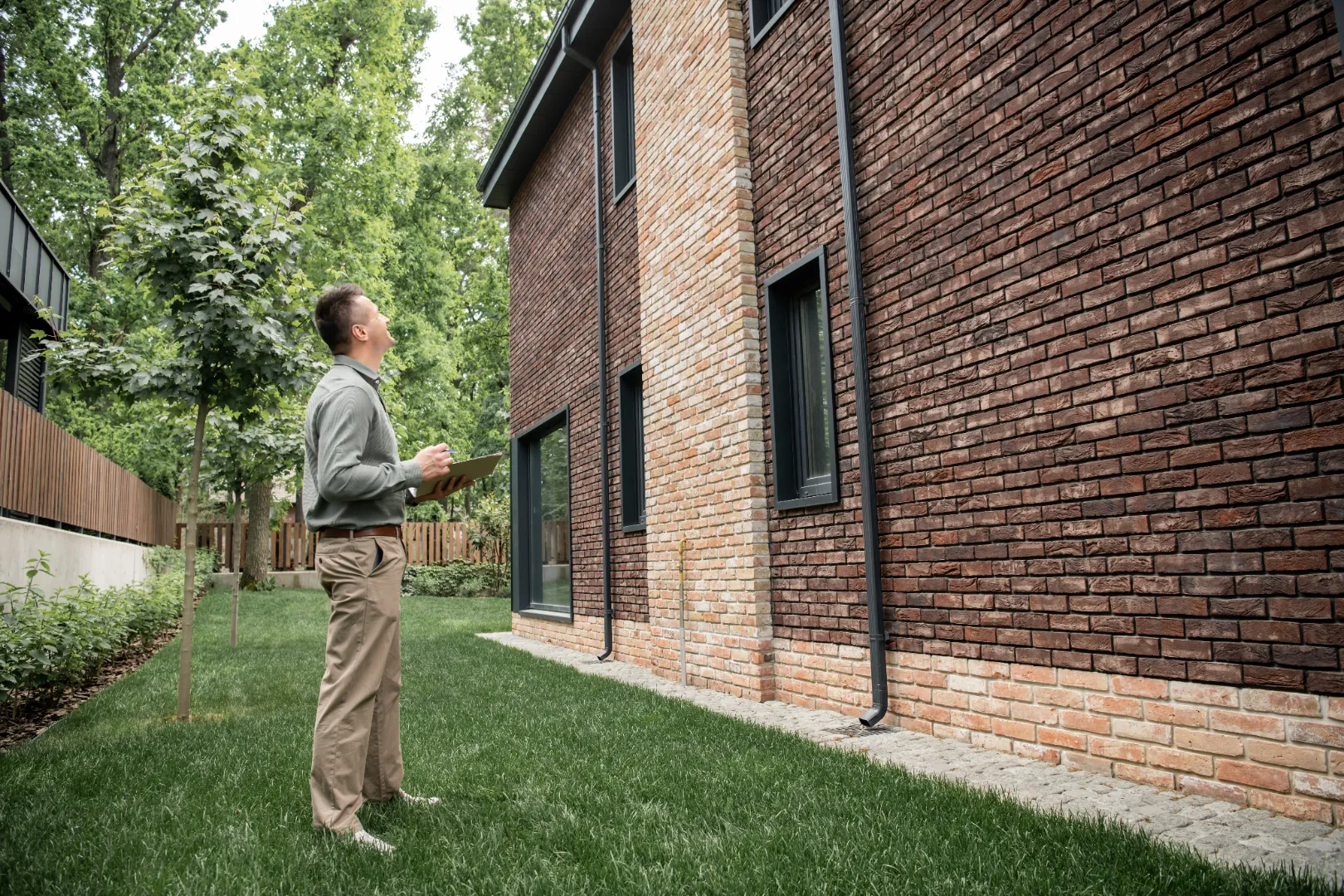 Homeowner inspecting a brick exterior before installing siding
